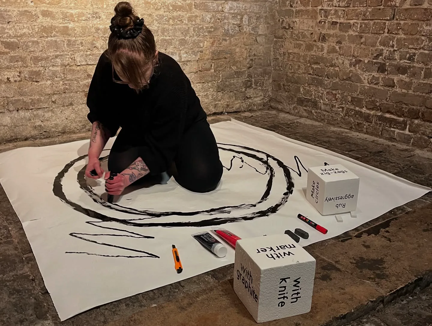 Artist drawing among works at the EXI exhibition