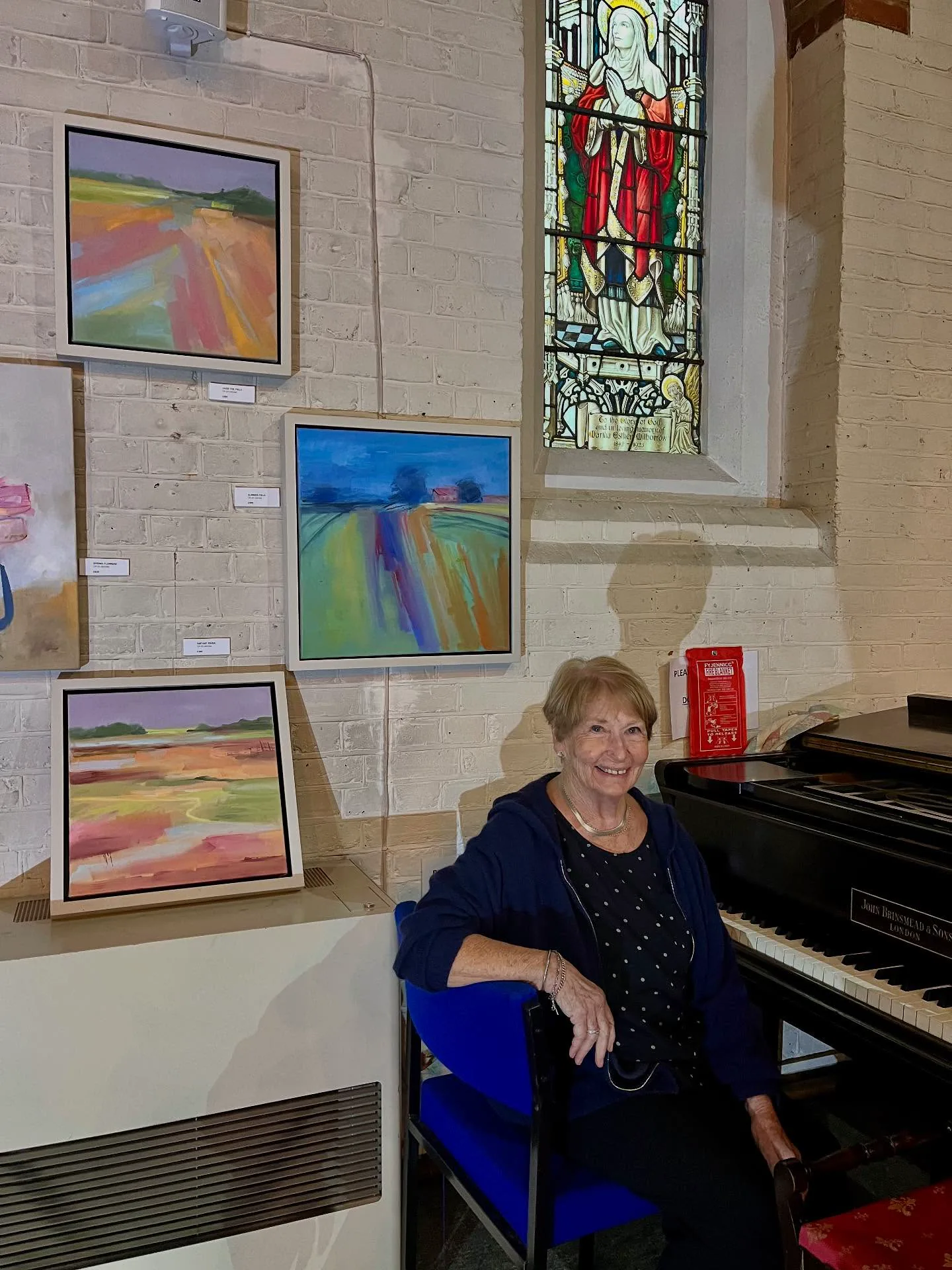 Artist beside the piano at the Crouch End exhibition
