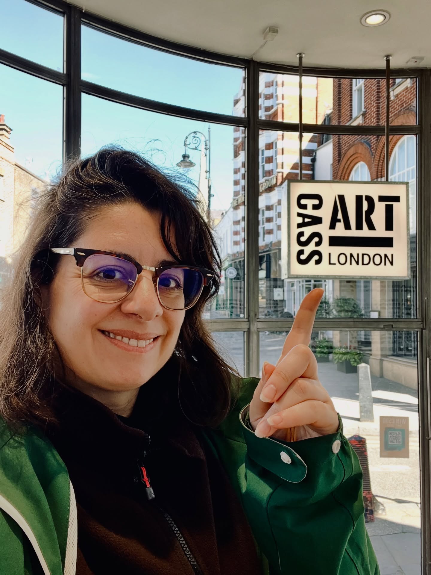 Kika Pierides pointing to the Cass Art London sign