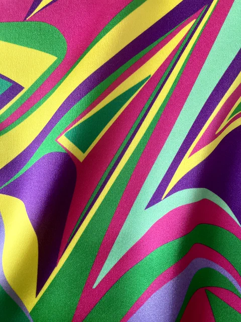 Candy Cane - 1, a vivid abstract textile design by Kika Pierides in pink, yellow, green, violet and mint, photographed in close-up with a soft fabric fold