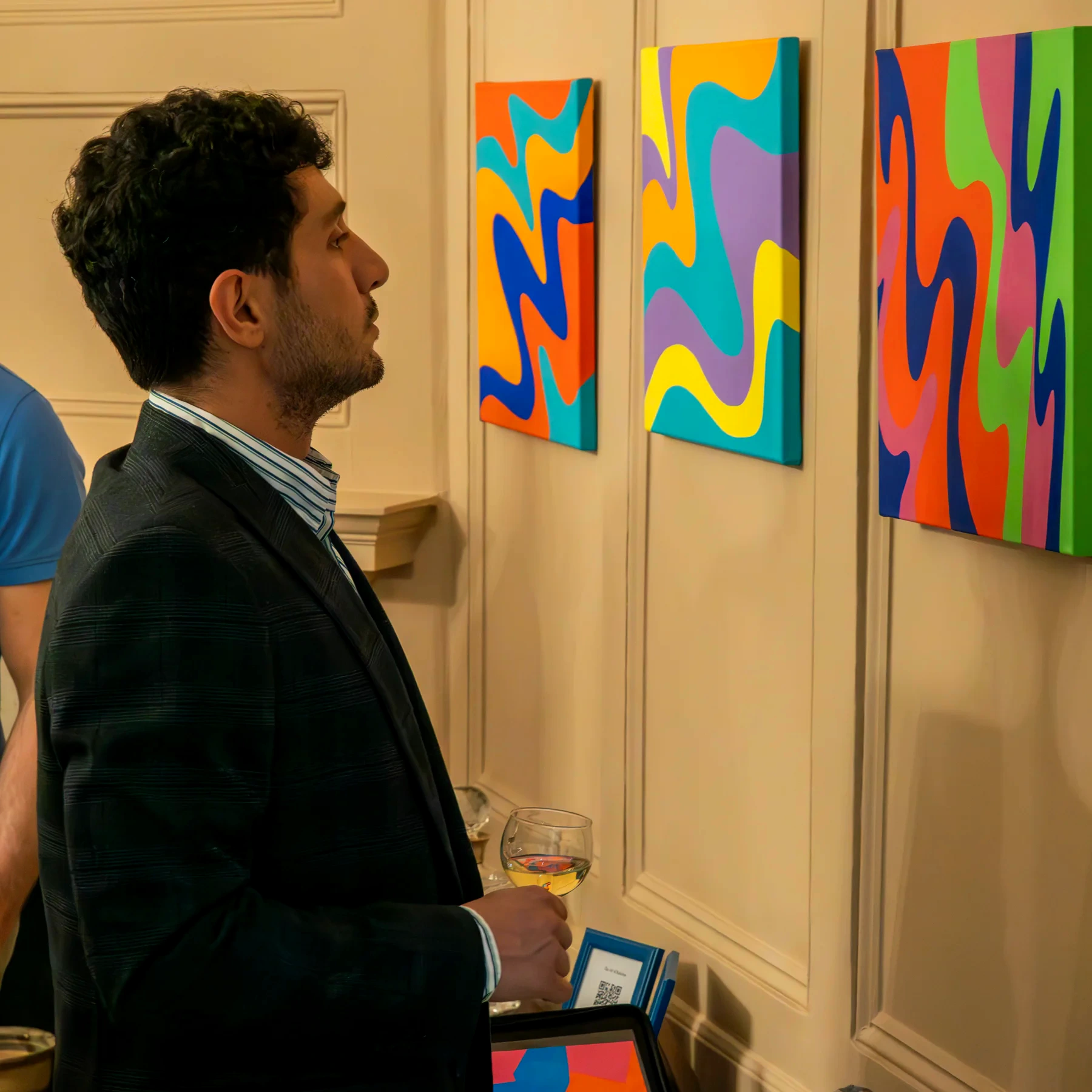 A visitor looking at colourful paintings in a formal room at the Cyprus High Commissioners Residence